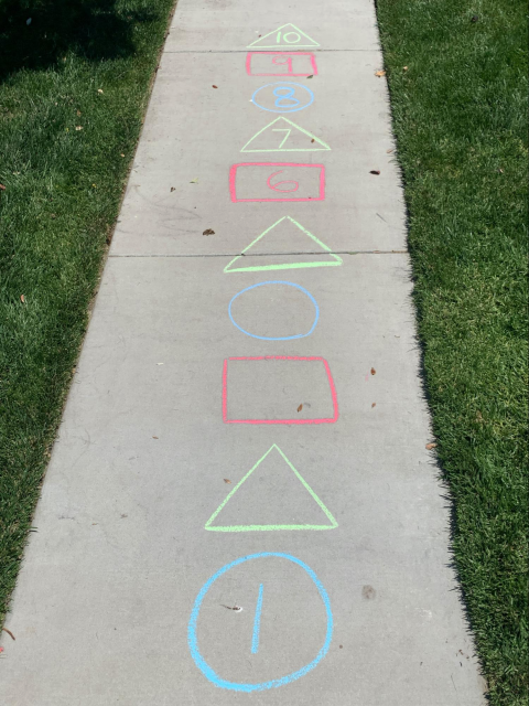 Sidewalk chalk shapes with numbers. Blue circle, 1. Green triangle, empty. Red rectangle, empty. Blue circle, empty. Green triangle, empty. Red rectangle, 6. Green triangle, 7. Blue circle, 8. Red rectangle, 9. Green triangle, 10.