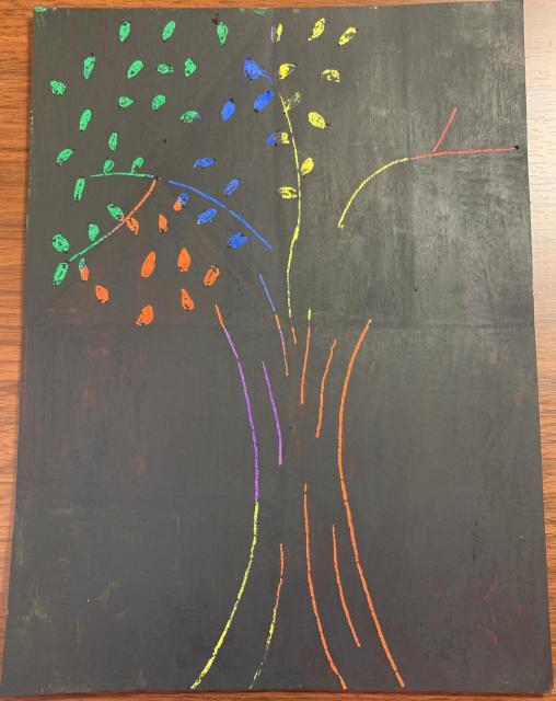 Paco raspó pedazos de pintura negra en forma de árbol. Se muestran los colores debajo de la pintura.