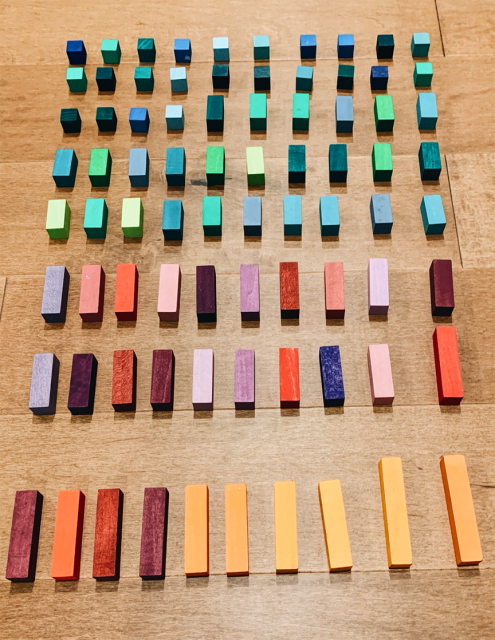 8 filas de bloques. Cada fila tiene 10 bloques. Los bloques en las 5 filas de arriba son más pequeños. Son azules y verdes. Los bloques en las 3 filas de abajo son más grandes. Son rojos, anaranjados, morados y rosados.