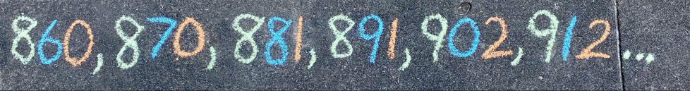 Someone wrote six 3-digit numbers in chalk on the sidewalk. The numbers are 860, 870, 881, 891, 902, and 912. In each number, the 1st digit is green, the 2nd digit is blue, and the 3rd digit is orange.